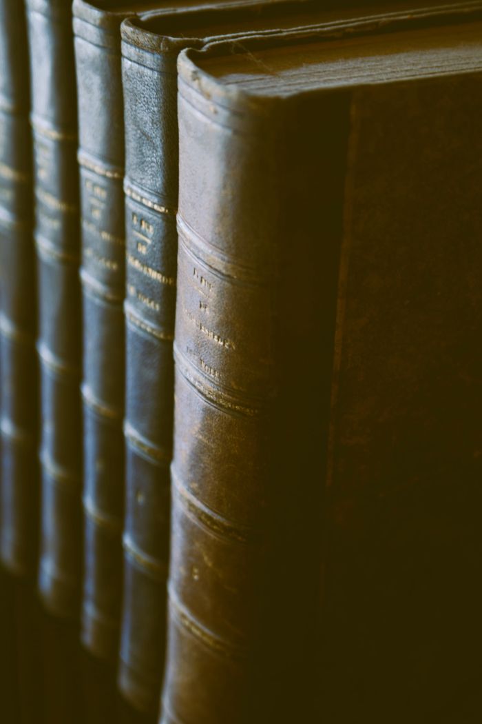 Home Close-up of vintage leather-bound books with elegant gold text.