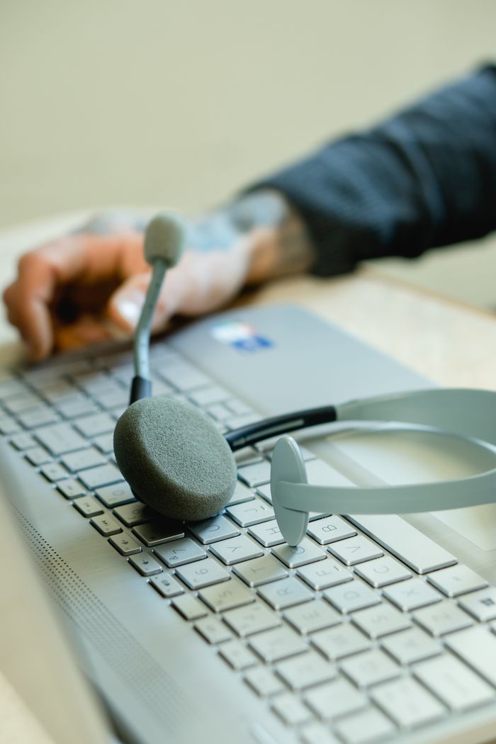 Home Close-up of a headset on a laptop keyboard, representing remote work and customer support.